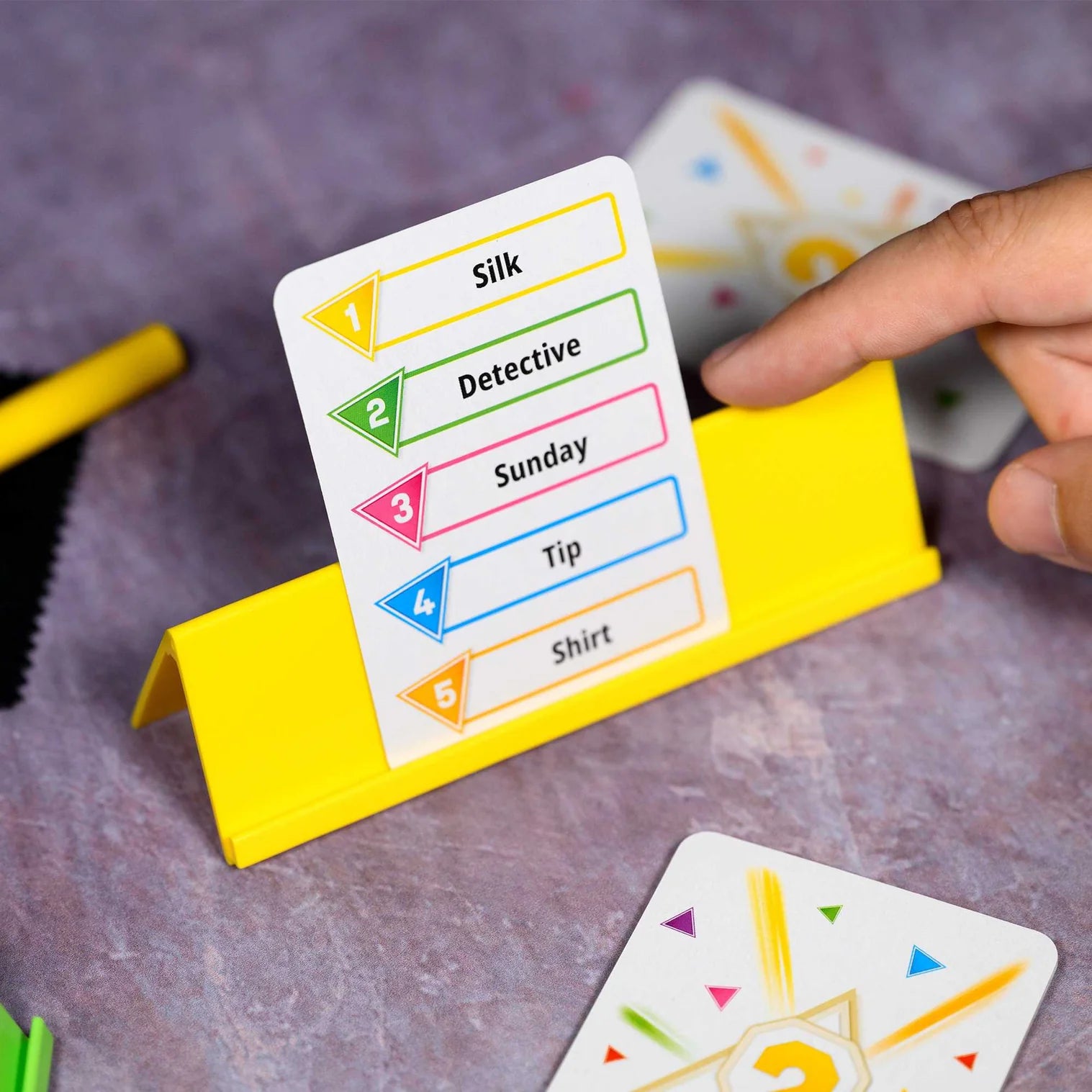 Card game with cards and a yellow card holder on a gray surface