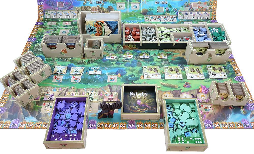 Board game with various components including cards, tiles, and boxes on a colorful board.