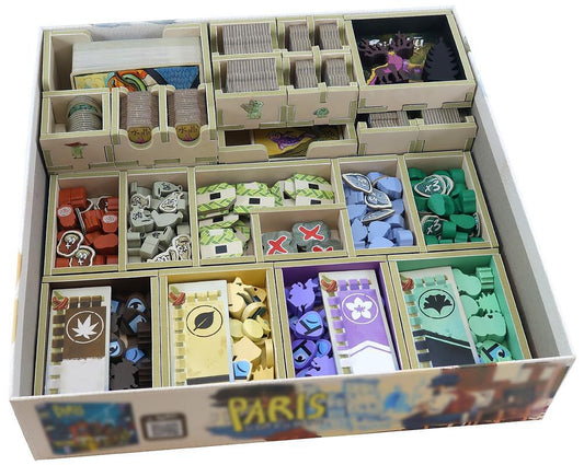 Board game box with compartments containing various game pieces and cards.