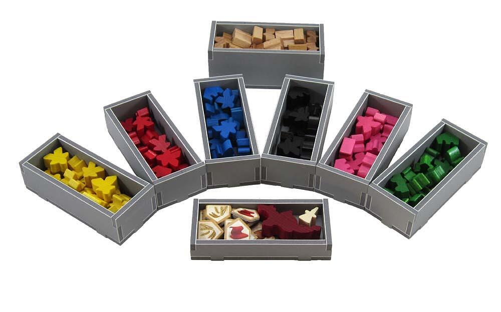 Set of color-coded storage boxes with various colored items inside on a white background