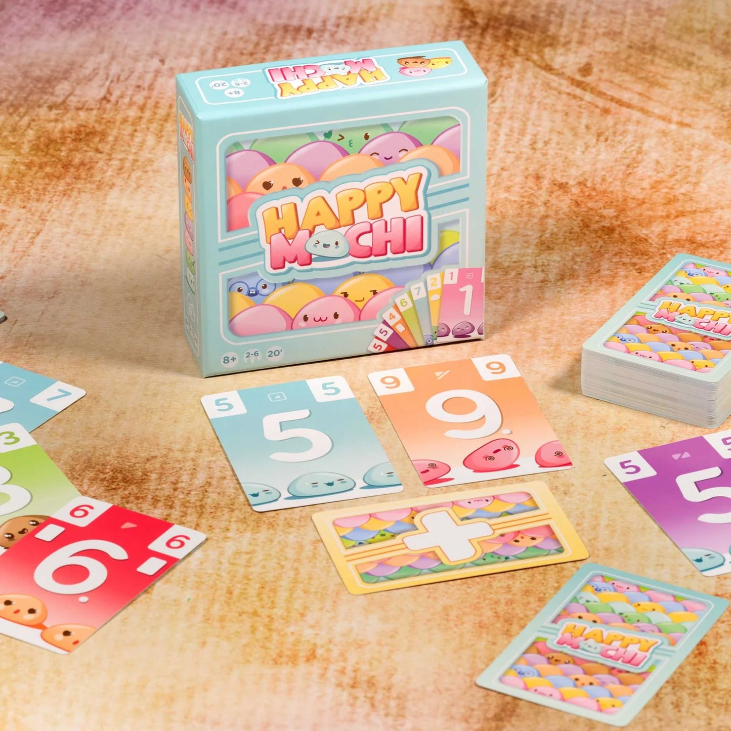Happy Mochi card game packaging and cards on a wooden surface