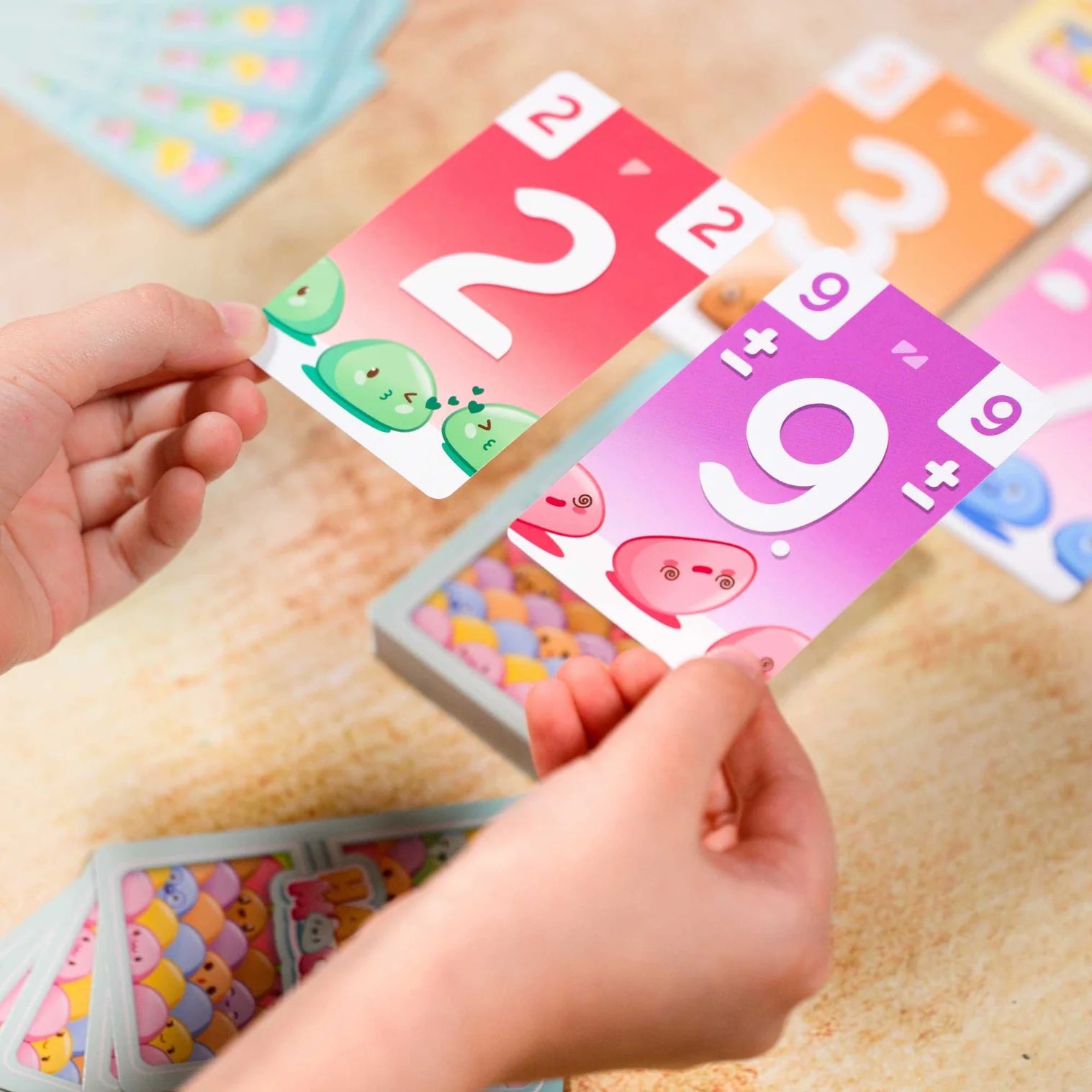 Children's hands playing with educational number cards on a wooden surface