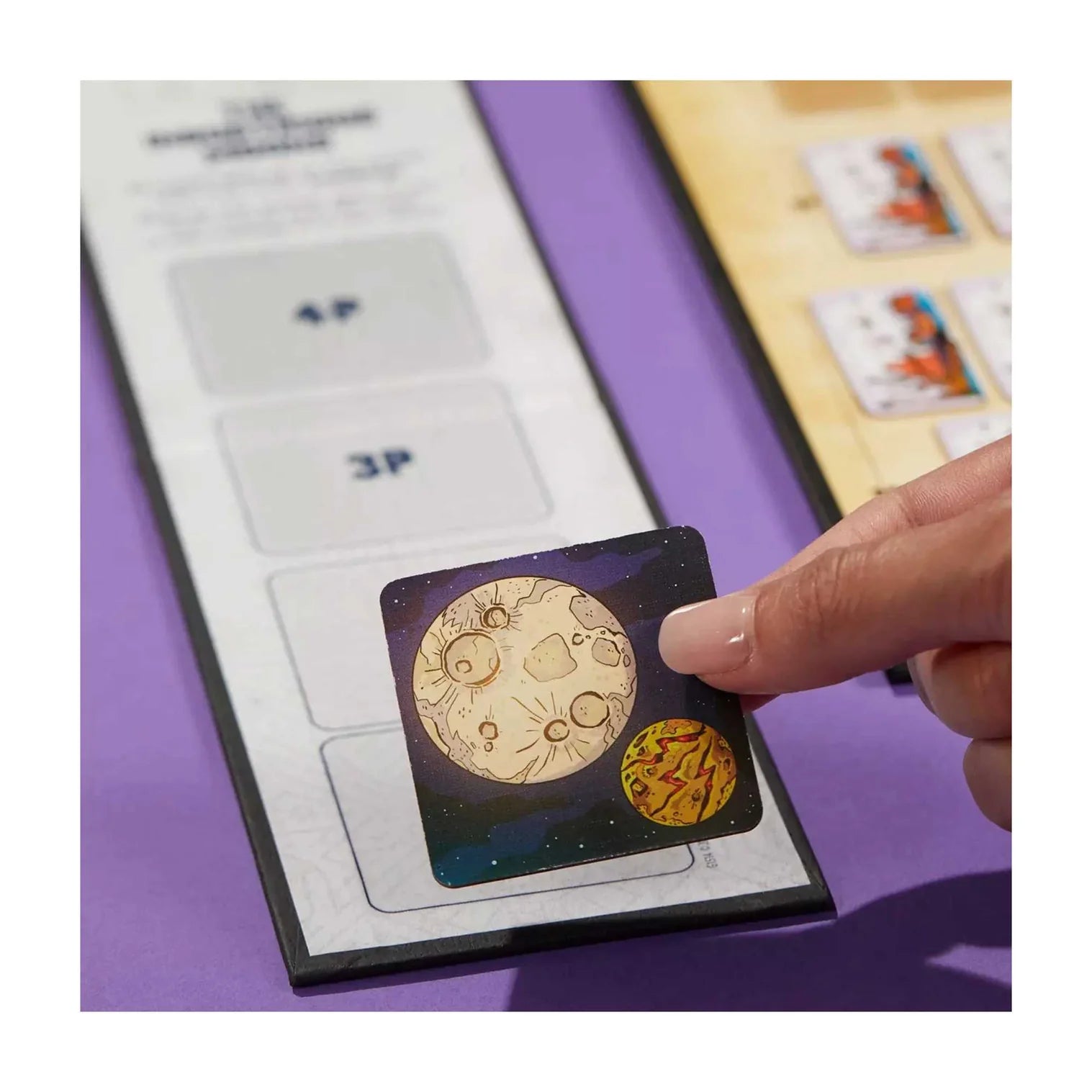 Hand holding a card with astrological symbols against a purple background