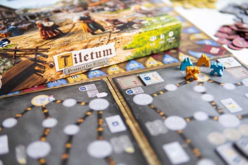 Board game with 'Tiletum' box and game pieces on a table