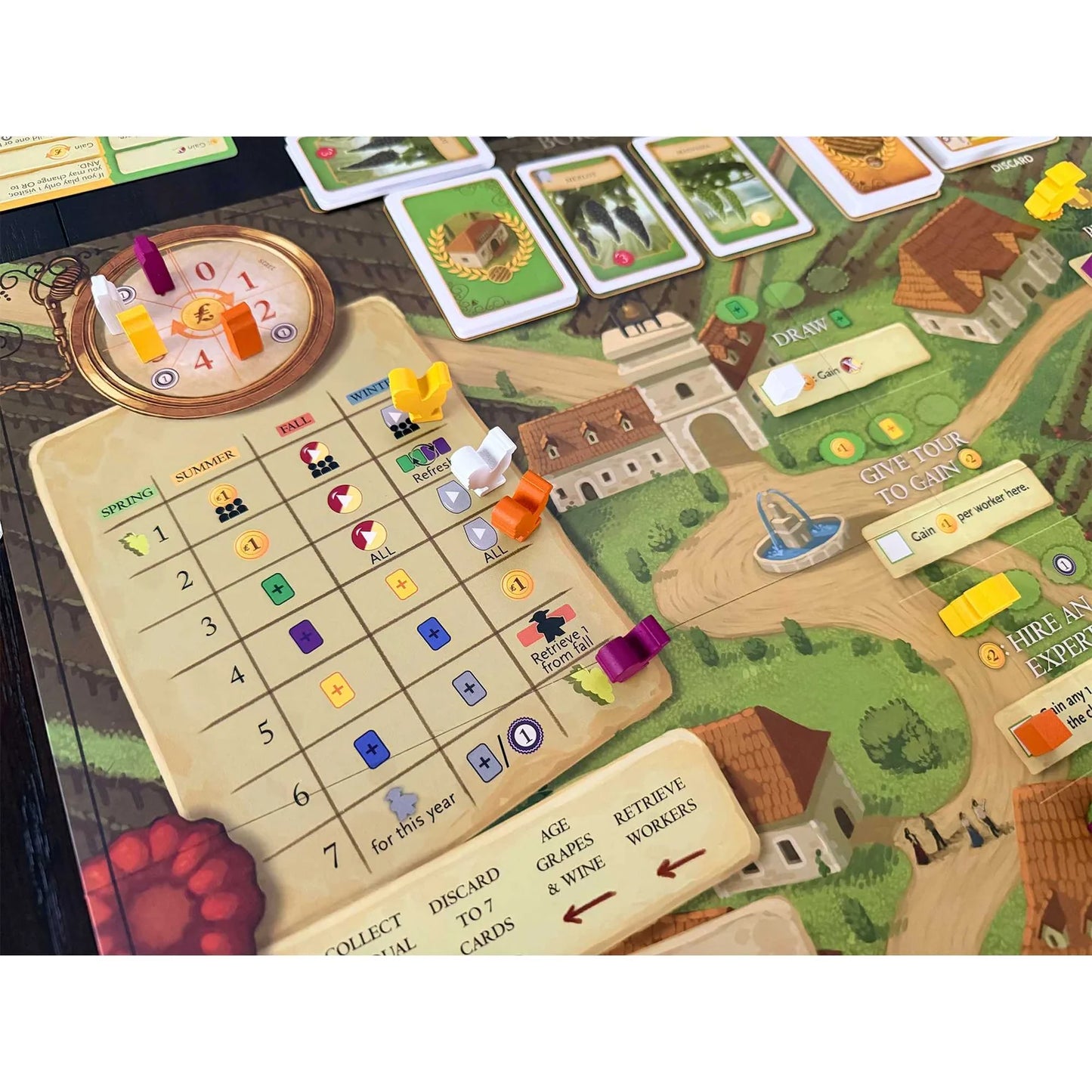 Board game setup with various components on a scenic board