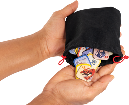 Black drawstring bag with colorful game cards held by a hand on a white background