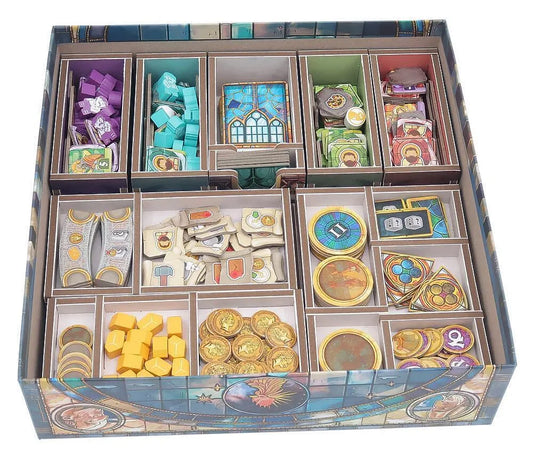 Board game box with compartments containing various game pieces and cards.