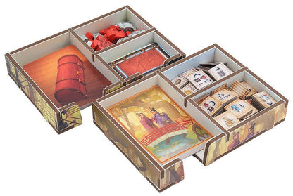 Board game box with compartments containing game pieces and cards on a white background